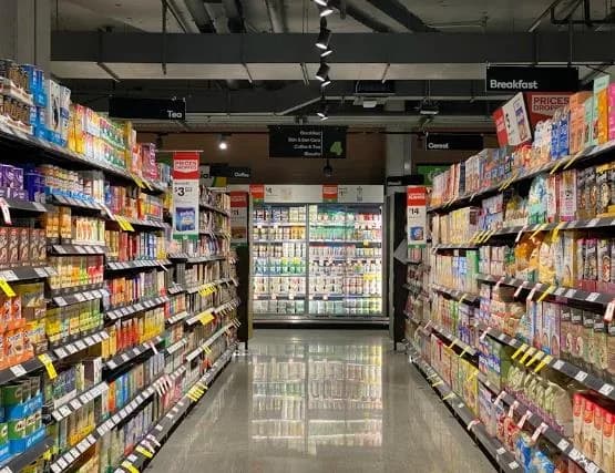 A brightly lit grocery aisle stocked with packaged goods